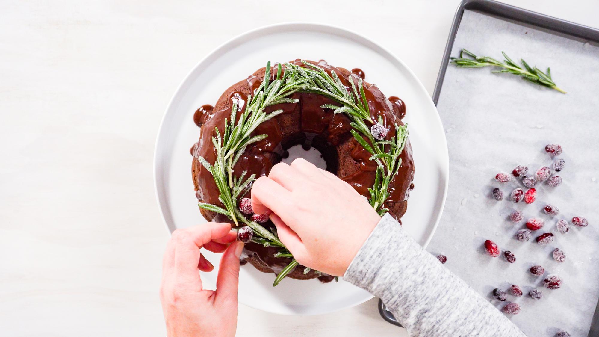 Close-up of hands garnishing tart